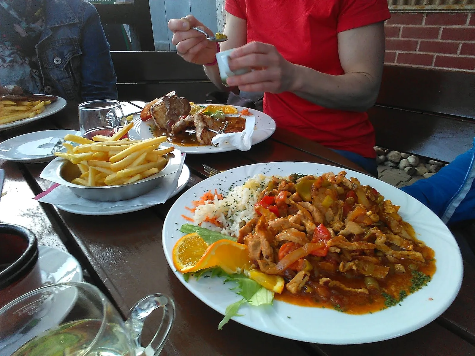 Tischszene im Biergarten des Schützenhauses mit Gästen und Speisen